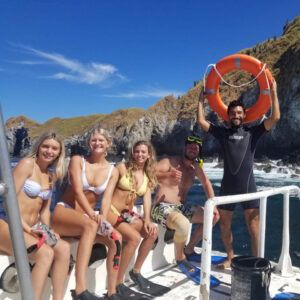 Group of happy girls with the instructor on the dive boat in Catalina Islands.