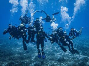 Grupo de buceadores bajo el agua durante un curso de buceo Open Water Diver