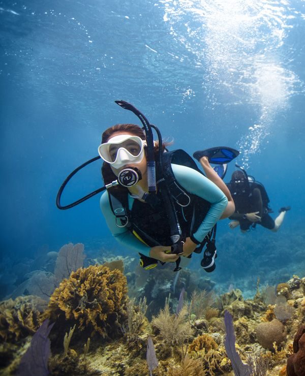 a diver with a white mask exploring the sea bed
