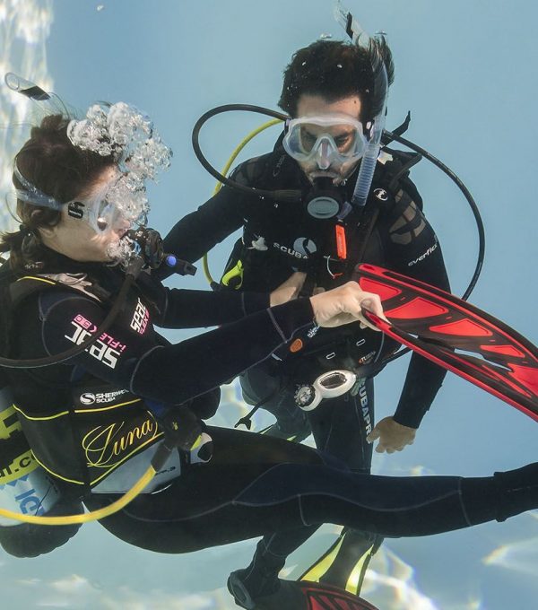 A diving instructor with a diving student training in a pool